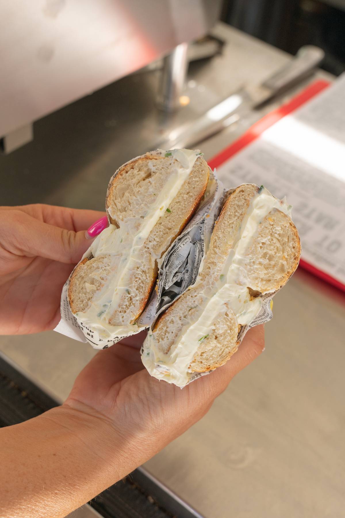Cream cheese bagel in hand